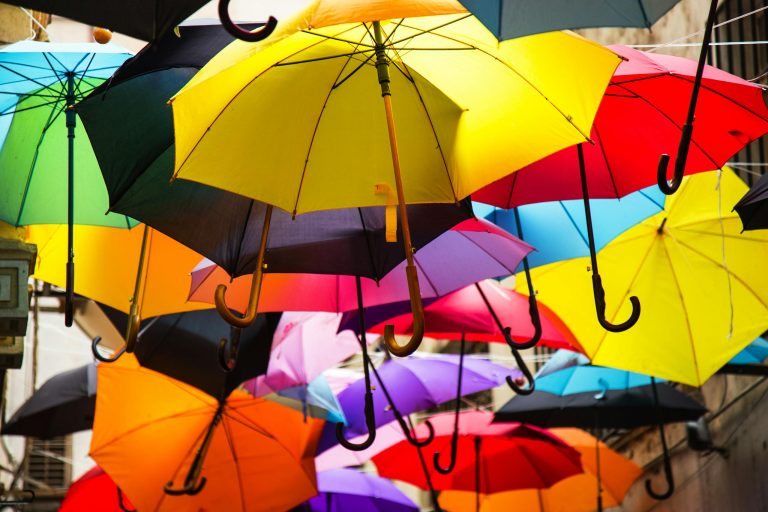Vibrant display of colorful umbrellas suspended outdoors, creating a lively atmosphere.