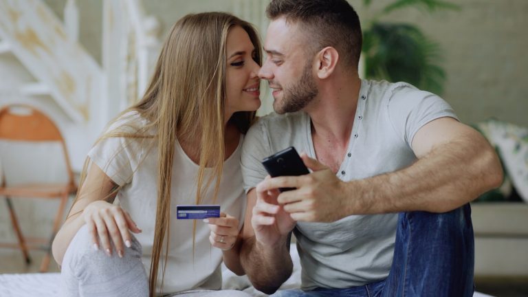 Couple holding credit card and smartphone