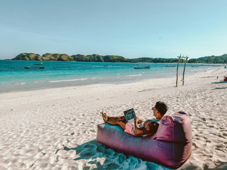 a man sitting on a bean bag on the beach