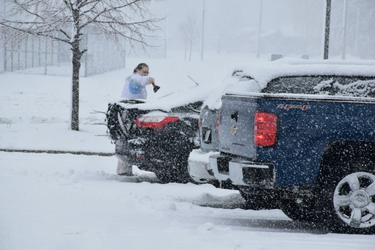 a woman standing on top of a truck in the snow