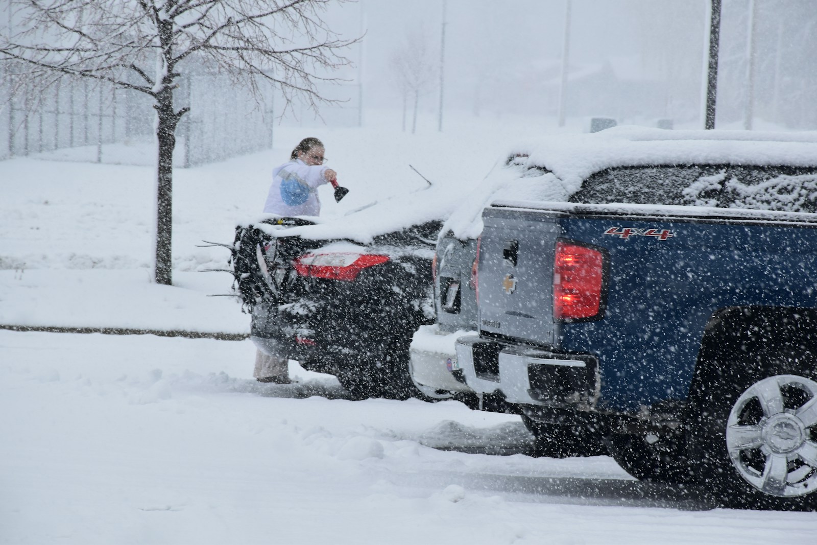 a woman standing on top of a truck in the snow